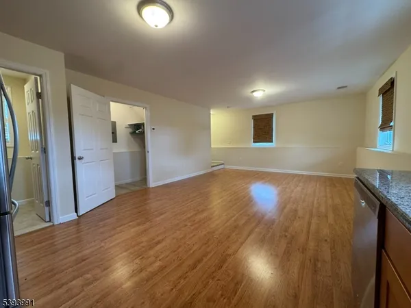 a view of empty room with wooden floor