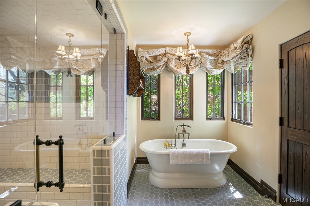 28087 North Shore Road Lake Arrowhead, CA 92352 - Photo 21 of 48 a bathroom with a bathtub and a chandelier