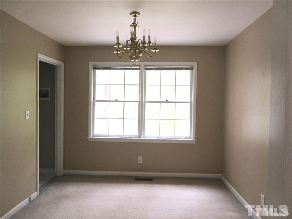 2729 Rothgeb Drive Raleigh, NC 27609 - Photo 5 of 14 an empty room with windows and chandelier