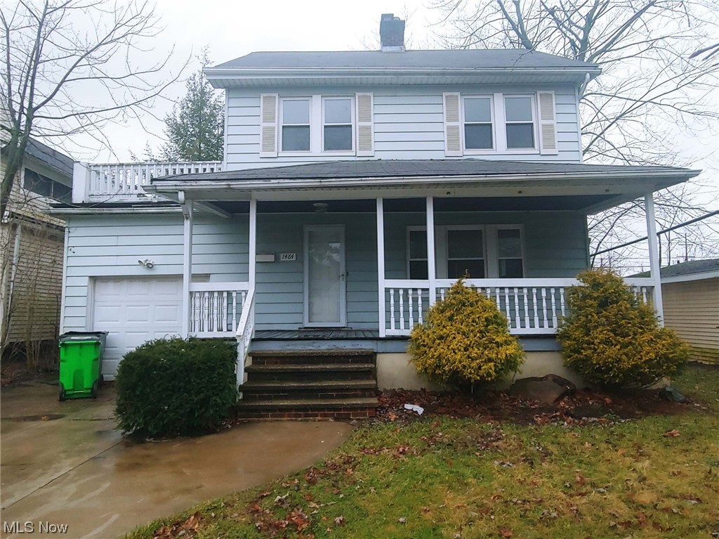 View of front of home with a garage and a porch