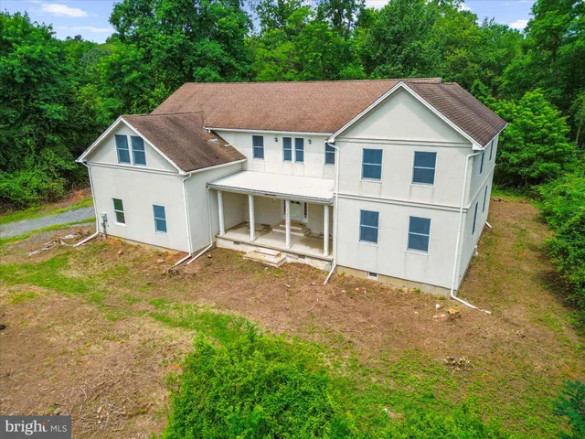 a view of a yard in front of a house with large trees