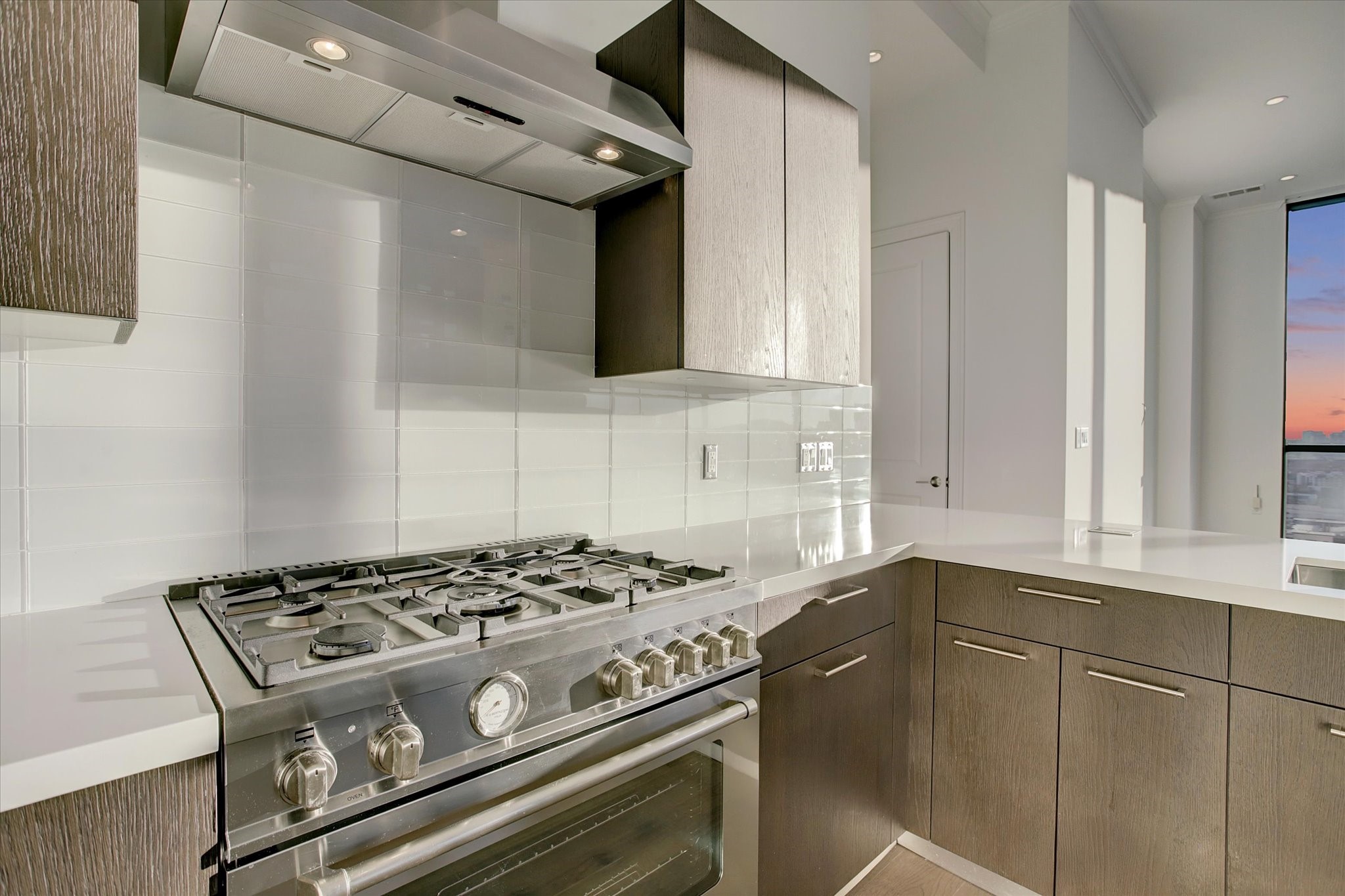 1211 Caroline Street, Unit 2002 Houston, TX 77002 - Photo 6 of 31 Custom tile backsplash and stainless steel 5-burner gas range