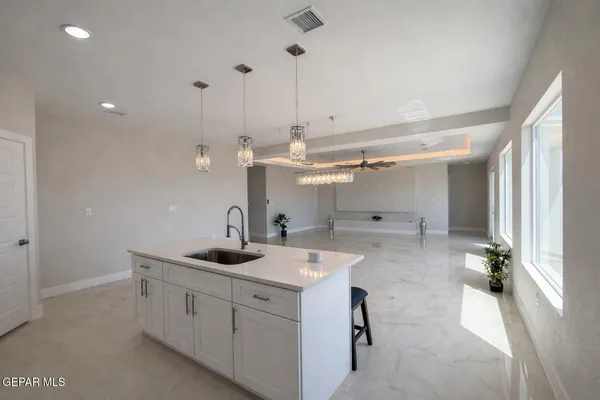 a kitchen with a sink stainless steel appliances and white cabinets