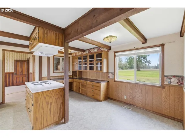a kitchen with a stove a refrigerator and wooden cabinets