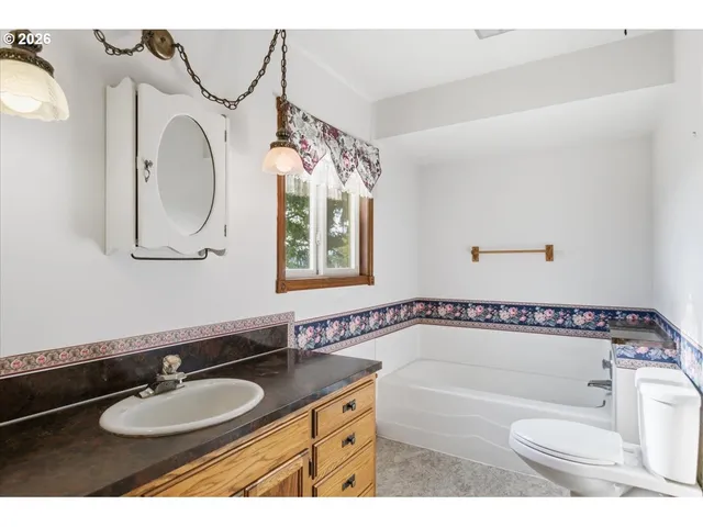 a bathroom with a bath tub a sink and a mirror
