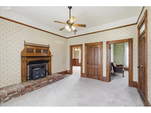 a view of an empty room with window and fireplace