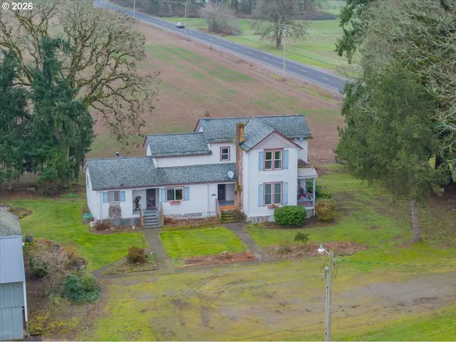 a aerial view of a house next to a yard with big trees