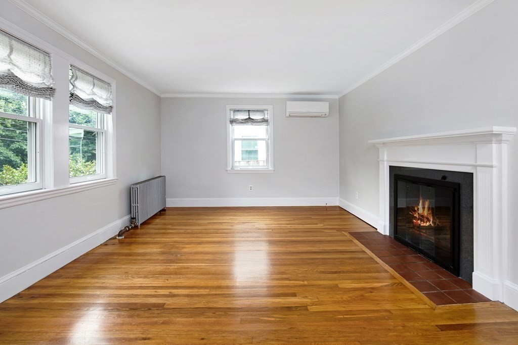 496 Marrett Road Lexington, MA 02421 - Photo 3 of 25 a view of empty room with wooden floor and fireplace