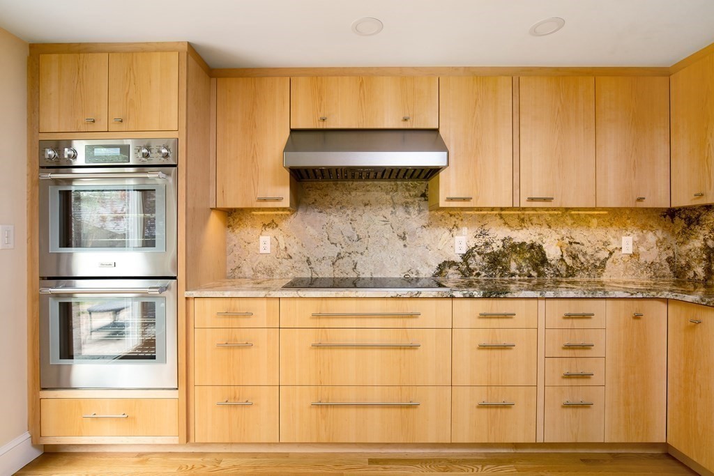 496 Marrett Road Lexington, MA 02421 - Photo 4 of 25 a kitchen with granite countertop white cabinets and stainless steel appliances
