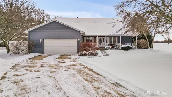 a front view of a house with a yard covered in snow