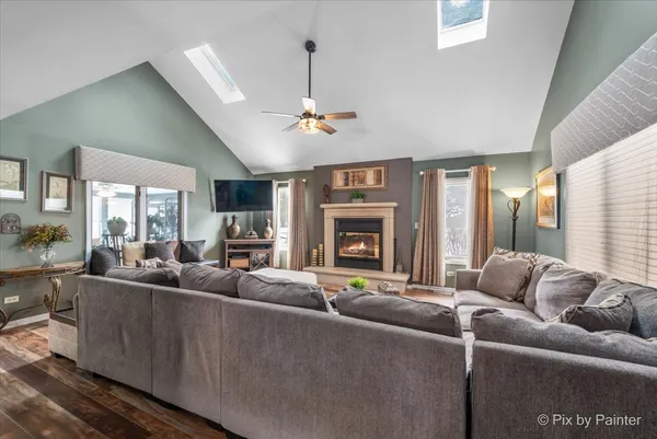 a living room with furniture a fireplace and a chandelier