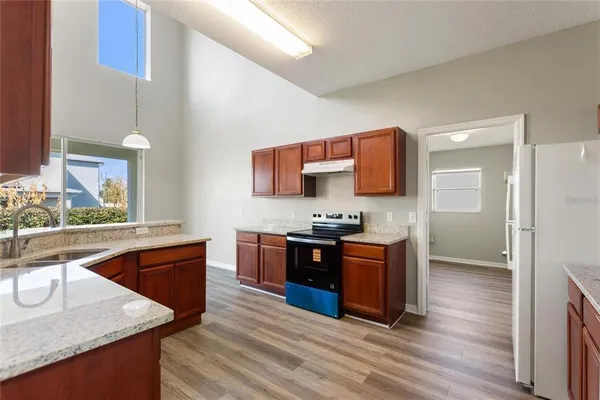a large kitchen with stainless steel appliances granite countertop a sink and wooden floor