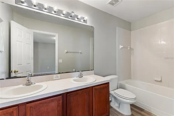 a bathroom with a double vanity sink toilet and a bathtub
