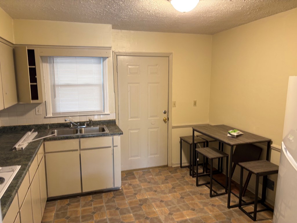 746 Fulton Avenue, Unit B Columbus, GA 31906 - Photo 2 of 7 a room with a sink a chair and a refrigerator