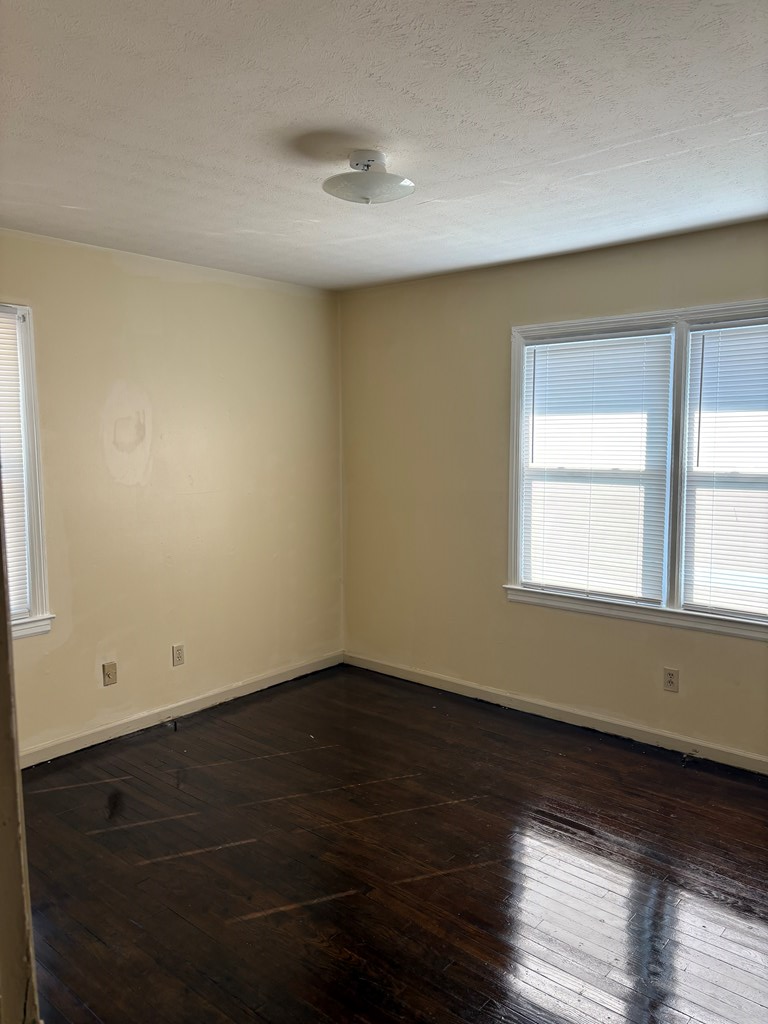 746 Fulton Avenue, Unit B Columbus, GA 31906 - Photo 5 of 7 a view of an empty room with wooden floor and a window