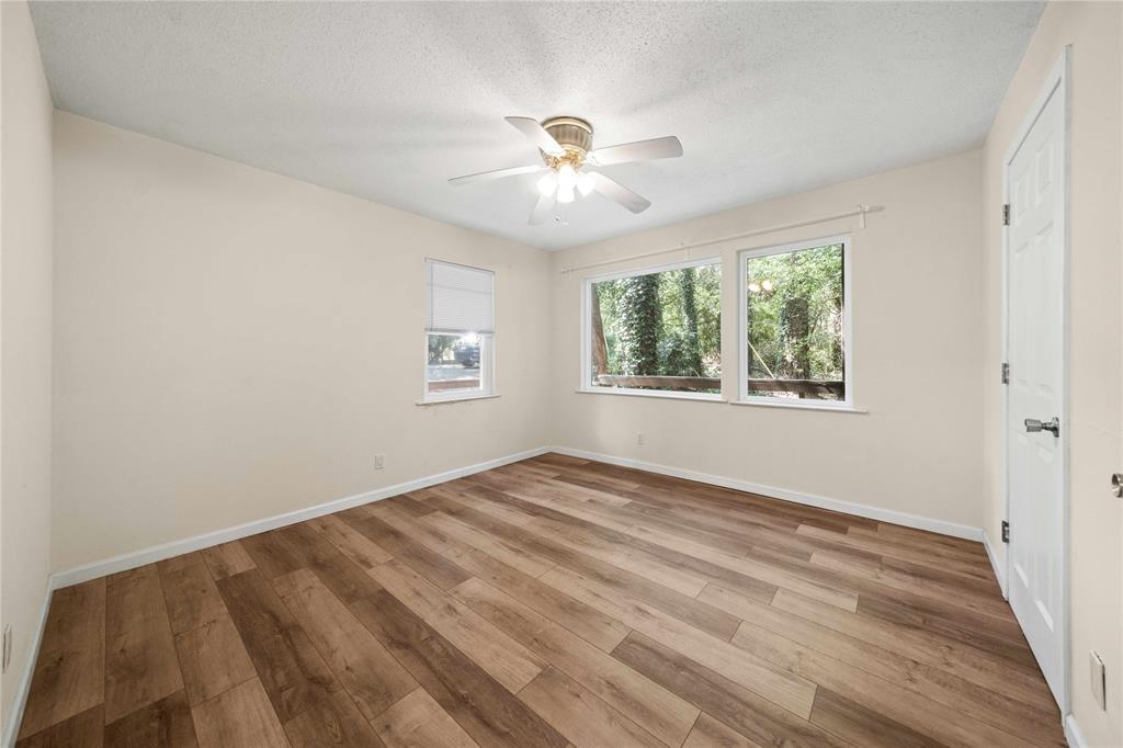 216 Pinewood Lane Hideaway, TX 75771 - Photo 16 of 40 a view of an empty room with wooden floor and a window