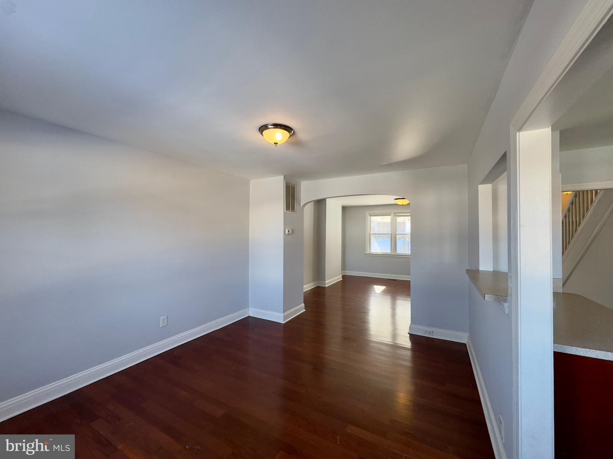 902 Andover Road Baltimore, MD 21218 - Photo 4 of 22 a view of an empty room with wooden floor and a window