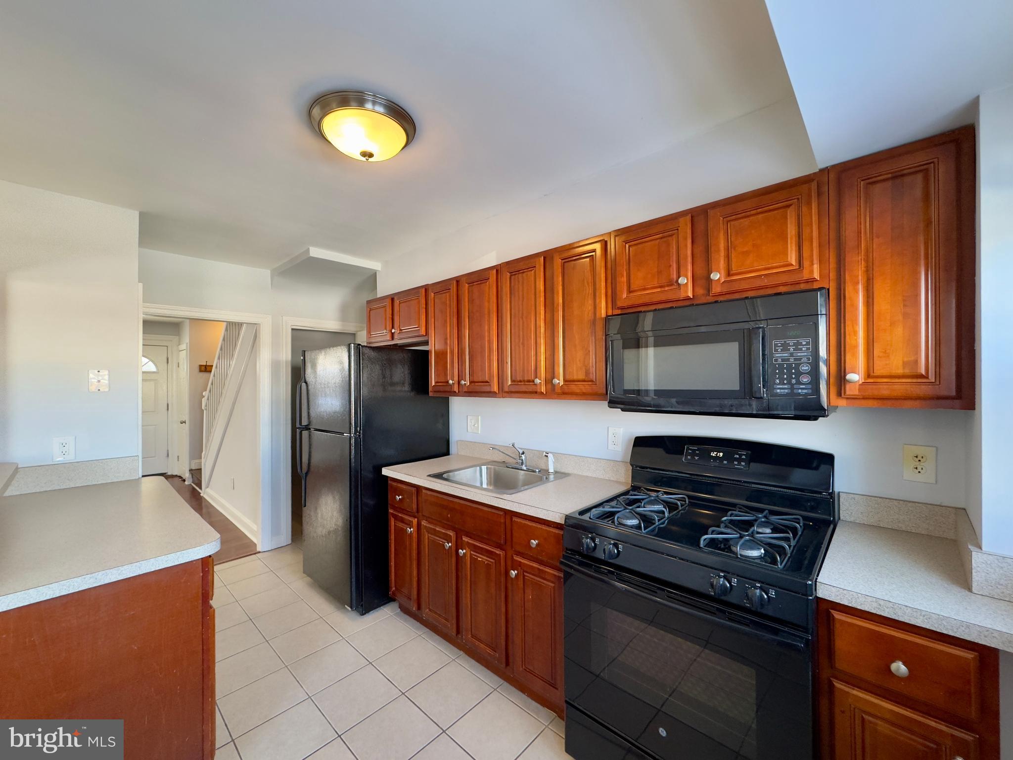 902 Andover Road Baltimore, MD 21218 - Photo 6 of 22 a kitchen with stainless steel appliances granite countertop a stove a refrigerator and a microwave