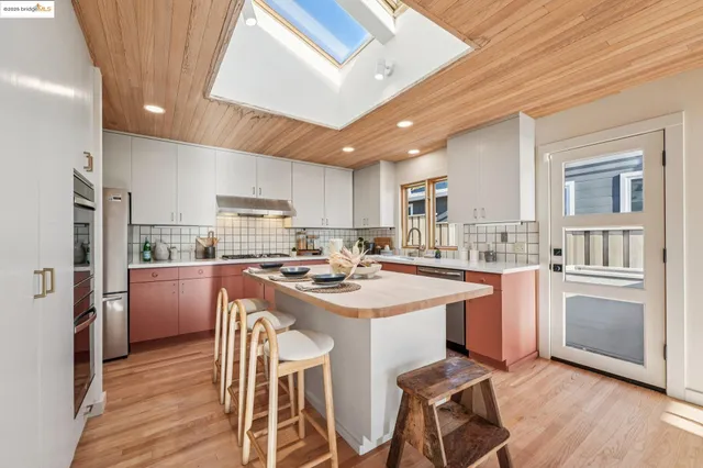 a kitchen with a sink appliances and wooden floor
