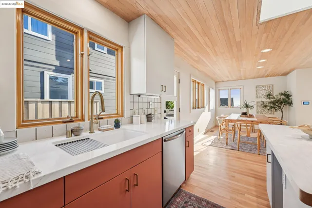 a dinning room and kitchen with a table chairs wooden floor