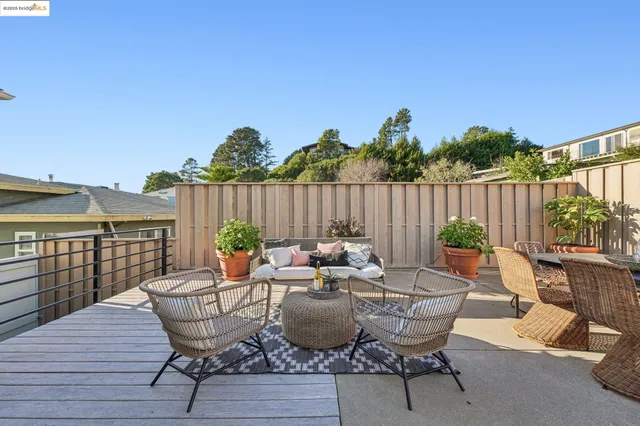 a view of a patio with couches and a potted plant on a table and chairs