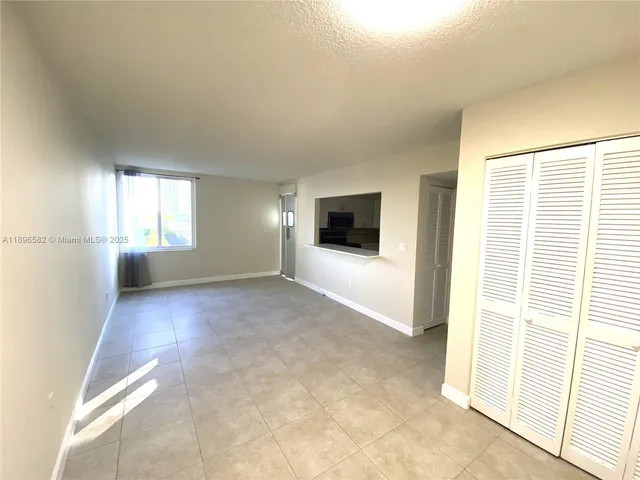 a view of a livingroom with an empty space and a window