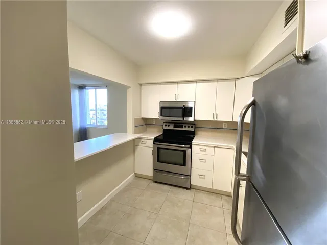 a kitchen with a sink appliances and cabinets