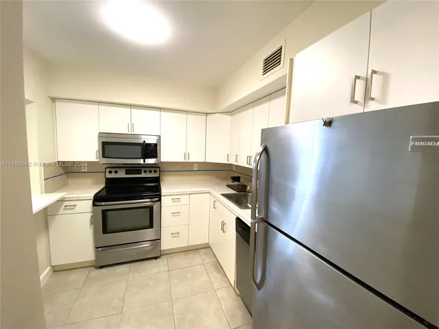 a kitchen with stainless steel appliances a refrigerator sink and microwave