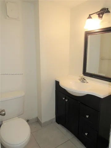 a bathroom with a sink vanity mirror and toilet
