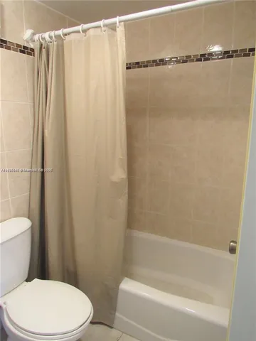 a white toilet sitting next to a bath tub