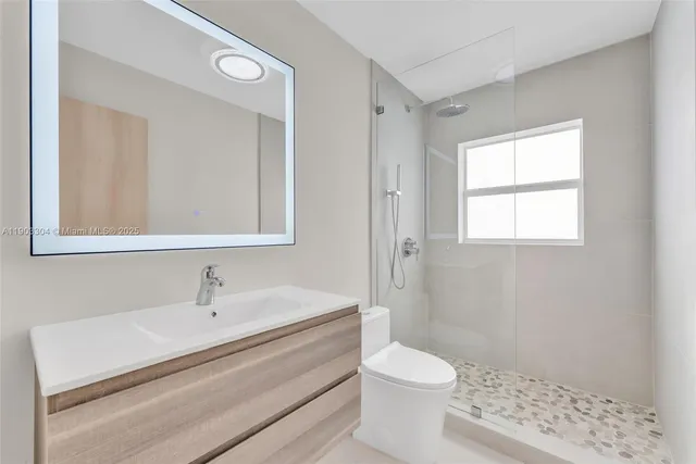 a bathroom with a sink a toilet and shower