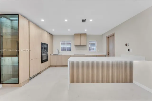 a living room with a large window and stainless steel appliances