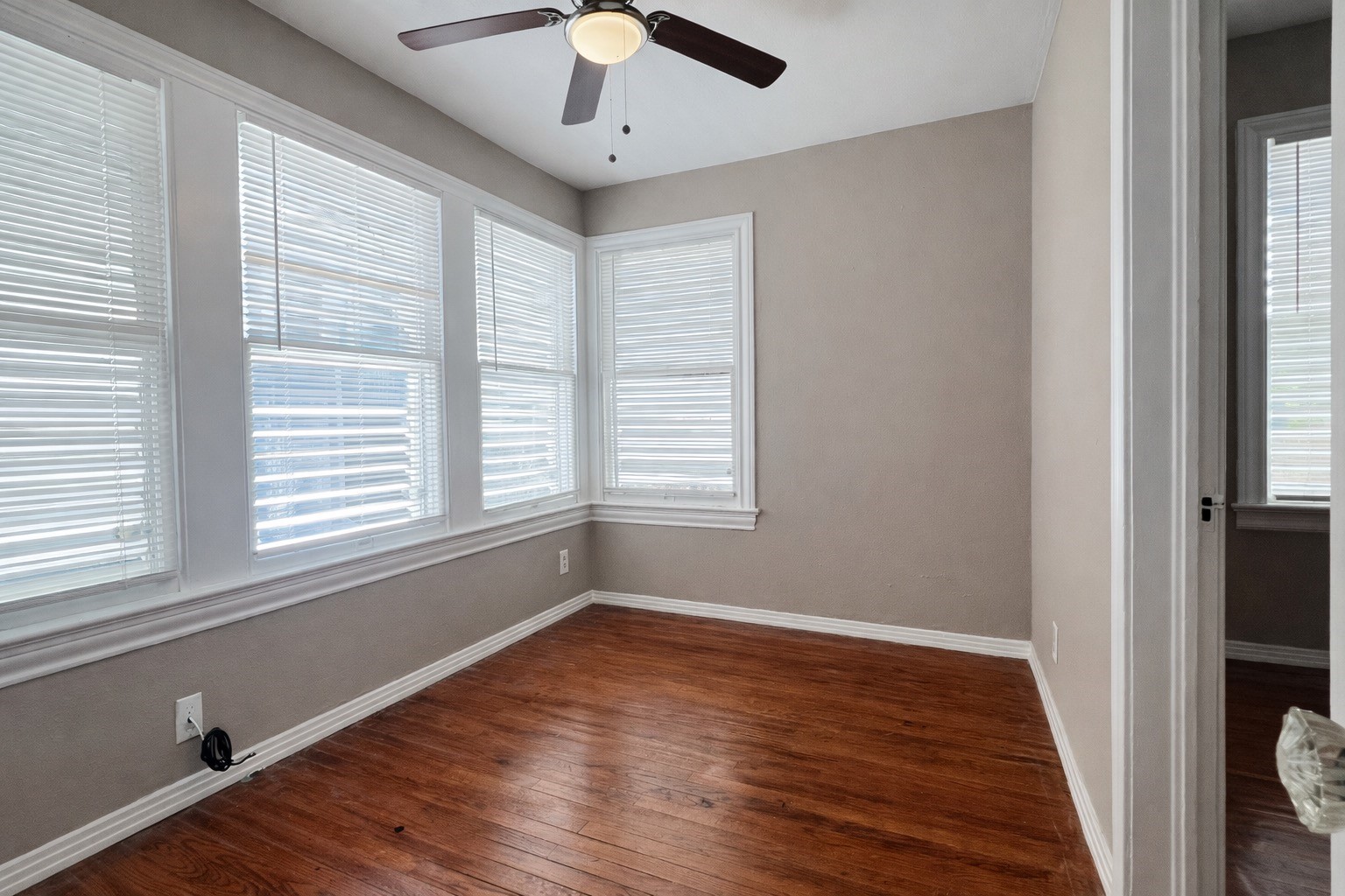 4917 Avenue R 1/2 Galveston, TX 77551 - Photo 16 of 21 Sunroom-style bedroom in Galveston Island home with multiple windows and hardwood floors.
