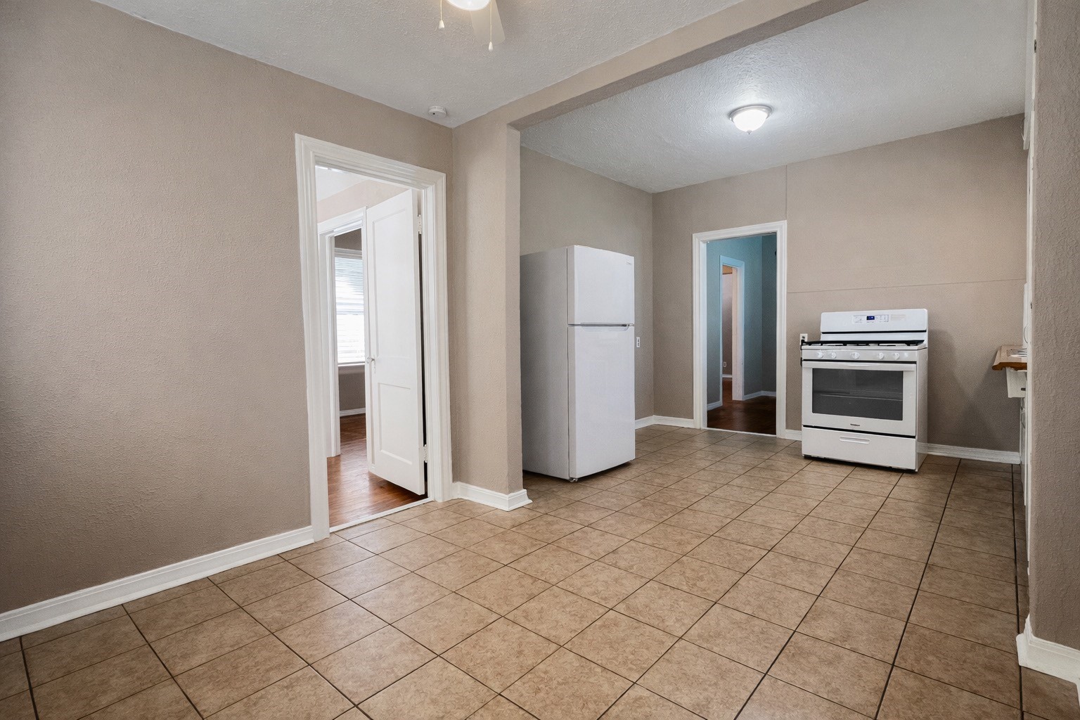 4917 Avenue R 1/2 Galveston, TX 77551 - Photo 7 of 21 Open-concept kitchen and living space in Galveston Texas featuring tile floors and updated white cabinetry.