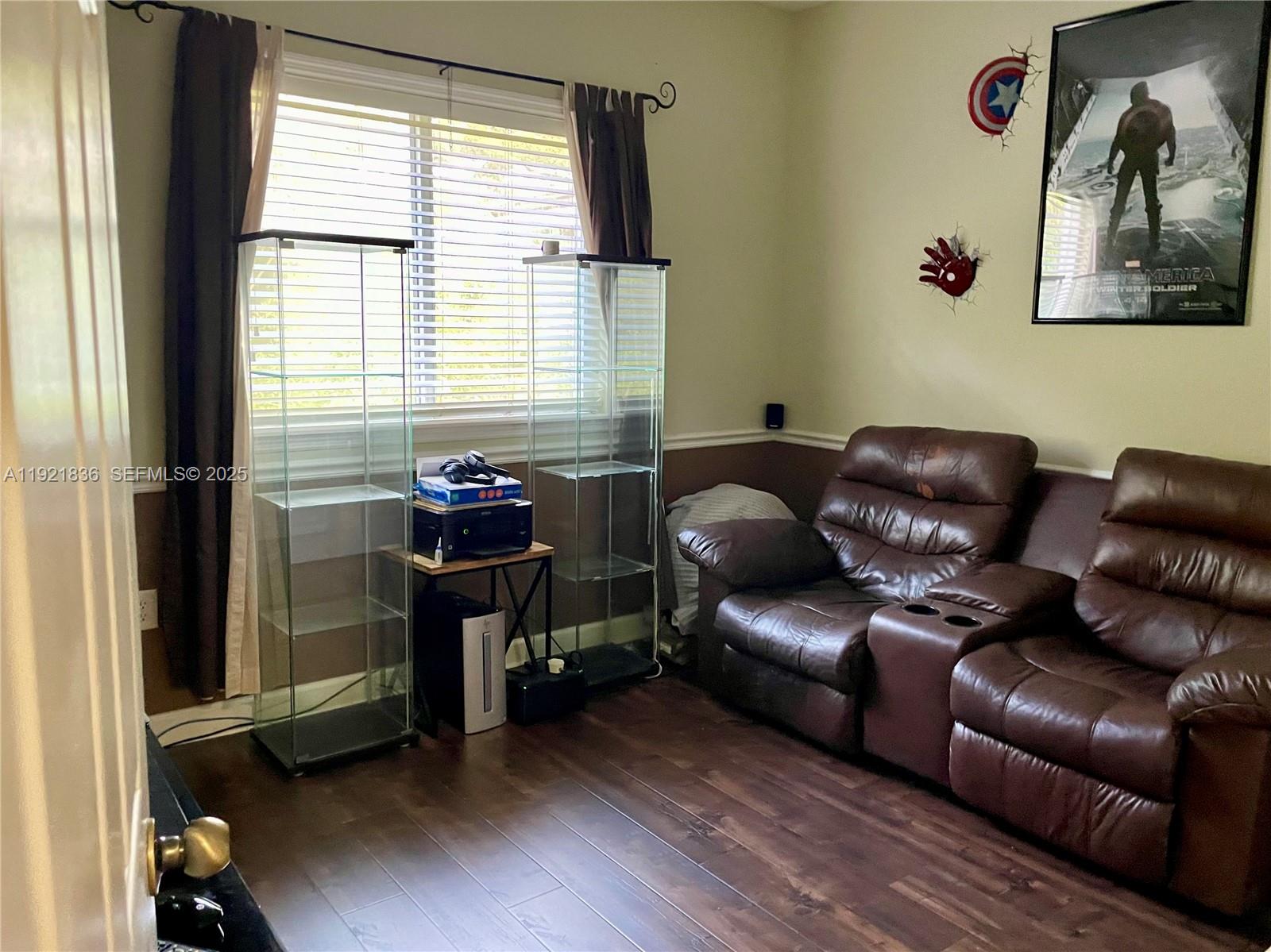 3121 Southeast 2nd Drive Homestead, FL 33033 - Photo 16 of 43 a blue couch sitting in a living room next to a window