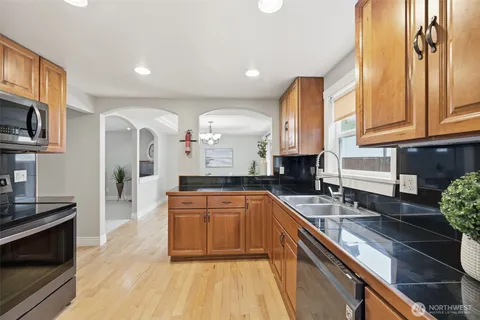 a kitchen with stainless steel appliances granite countertop a sink stove and cabinets