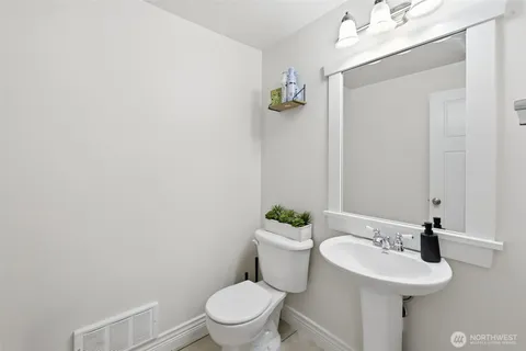 a bathroom with a sink mirror and toilet