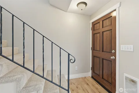 a view of staircase with railing and white walls