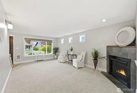 a living room with furniture a fireplace and a large window