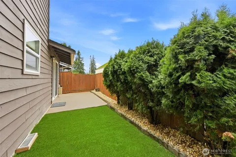 a front view of a house with a garden and trees