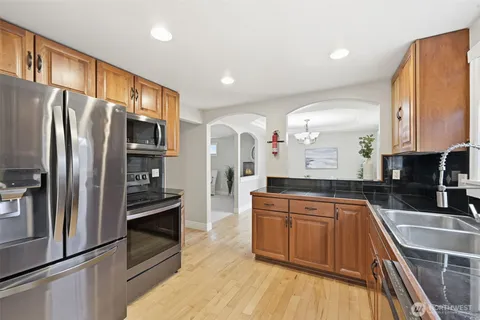 a kitchen with stainless steel appliances a refrigerator sink and microwave