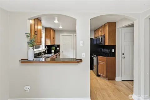 a view of a kitchen with kitchen island granite countertop a refrigerator and a sink