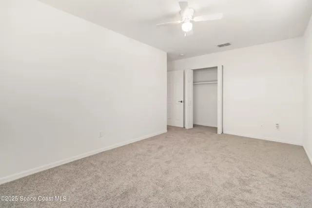 an empty room with a ceiling fan and a fan