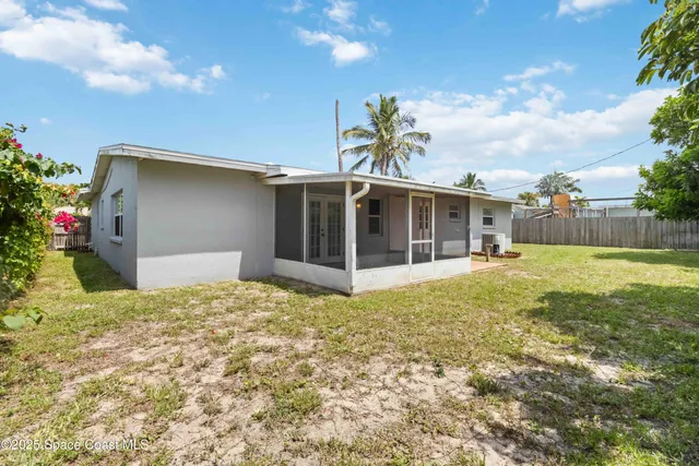 a view of a house with a yard and potted plants