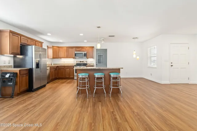 a view of a kitchen with dining room and wooden floor