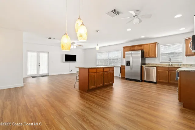 a kitchen with stainless steel appliances a refrigerator and wooden floor