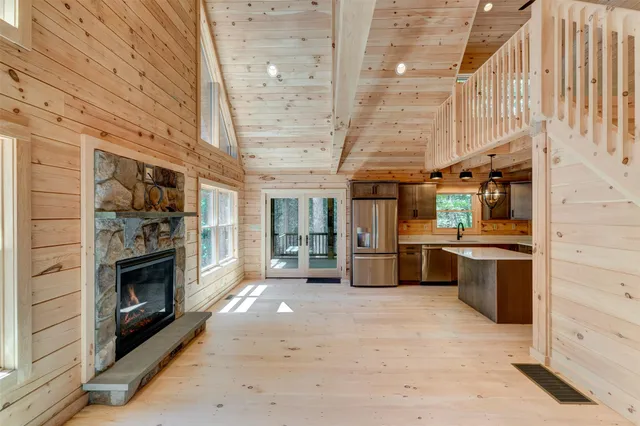 a view of a kitchen with a sink and dishwasher a fireplace with wooden floor
