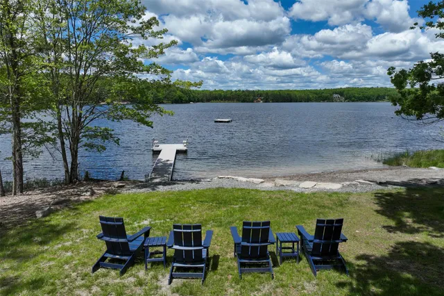 a view of yard with seating area and trees in the background