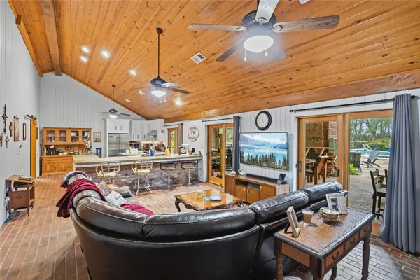a kitchen with stainless steel appliances granite countertop a stove a refrigerator a oven a dining table and chairs with wooden floor
