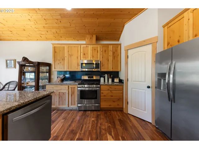 a kitchen with stainless steel appliances granite countertop a sink and wooden cabinets